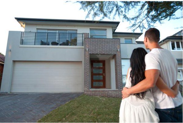 young couple in front of home